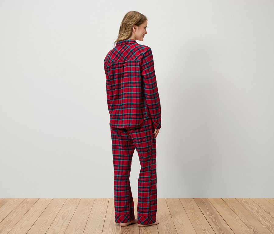 Une femme, vue de dos, porte un pyjama à carreaux rouge.