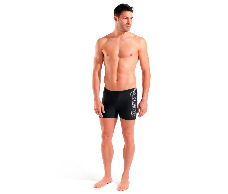 Un homme debout porte un maillot de bain arena Scratchy noir.