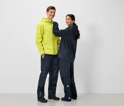 Deux personnes en vestes et pantalons de pluie, un homme en jaune et une femme en bleu marine.