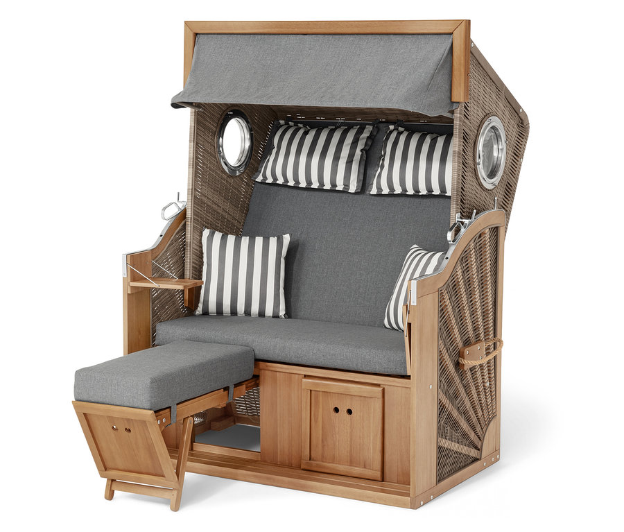 Un fauteuil de plage en osier et en bois avec des coussins gris et des coussins rayés.