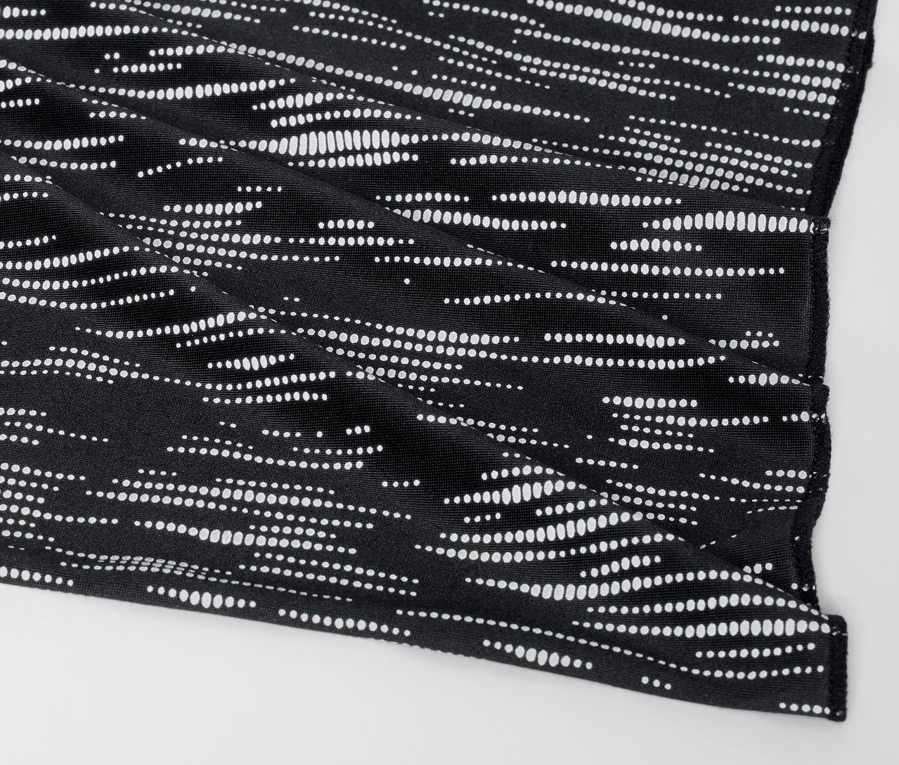Gros plan d'une housse en tissu noir avec un motif à pois blancs.