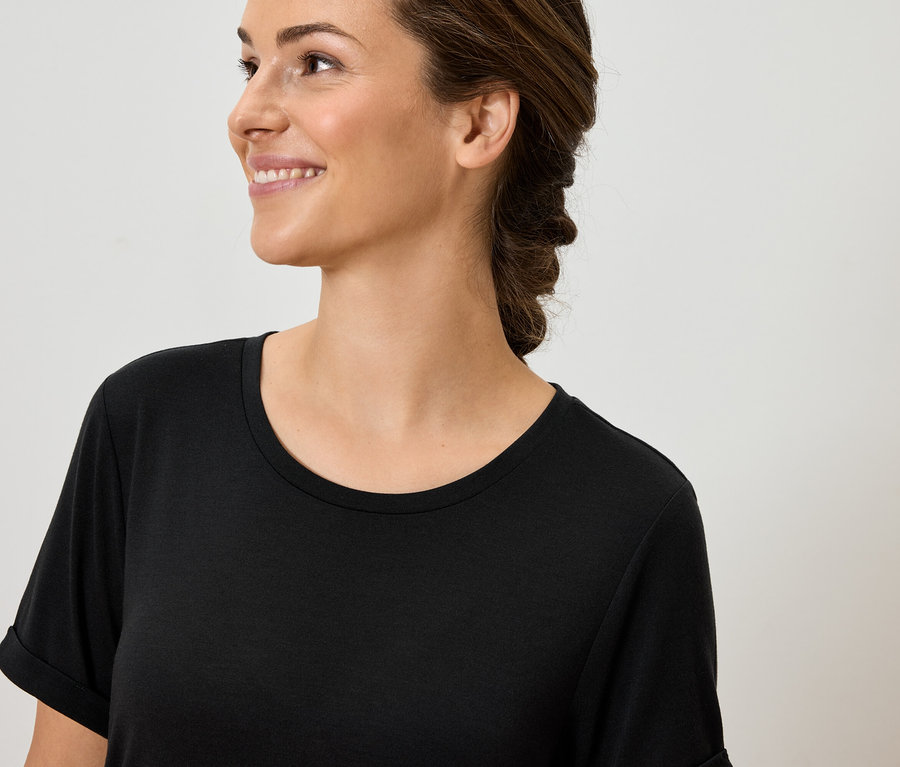 Portrait d'une femme souriante portant un t-shirt noir.