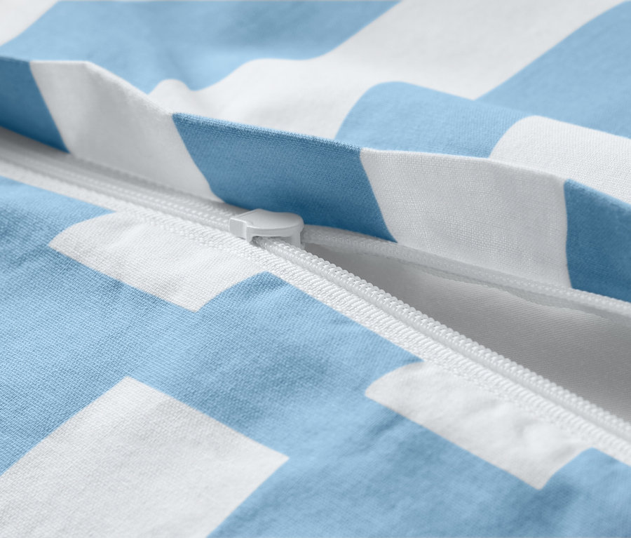 Gros plan d'une parure de lit en renforcé bleu et blanc rayé avec fermeture éclair.