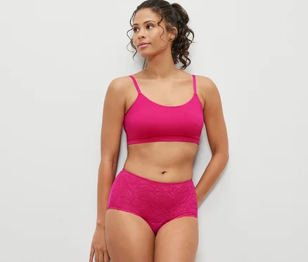 Femme posant en soutien-gorge rose et culotte taille haute « light-shaping » fuchsia.