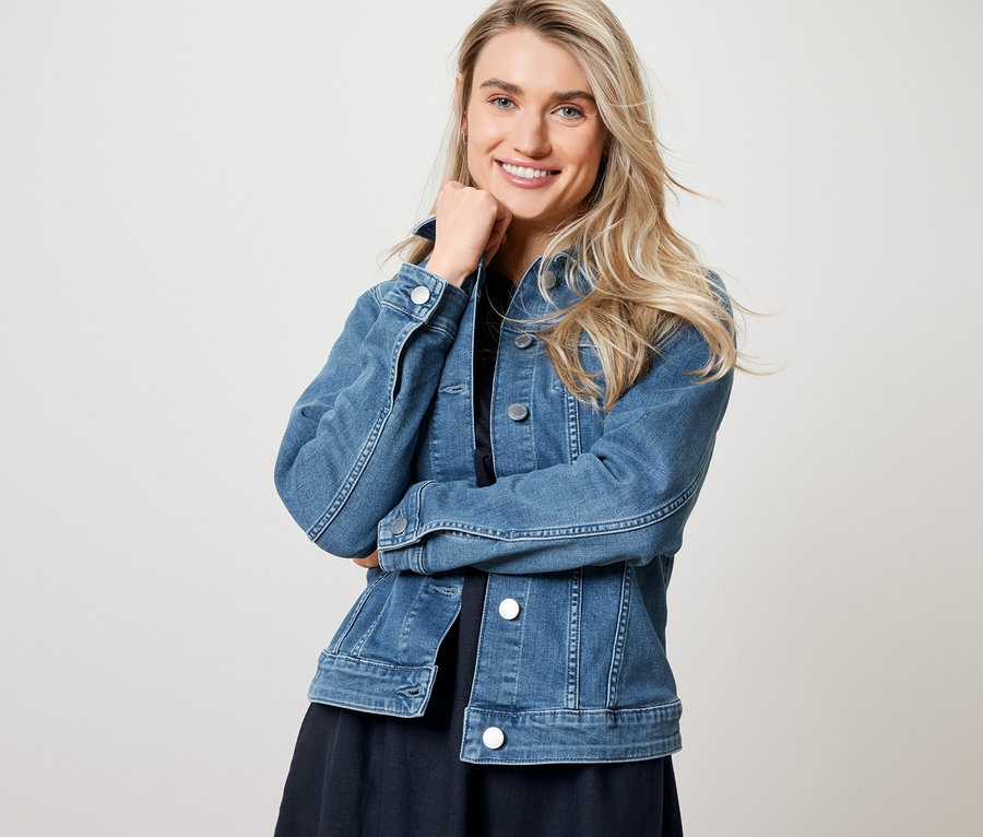 Femme posant en veste en jean et robe en lin.