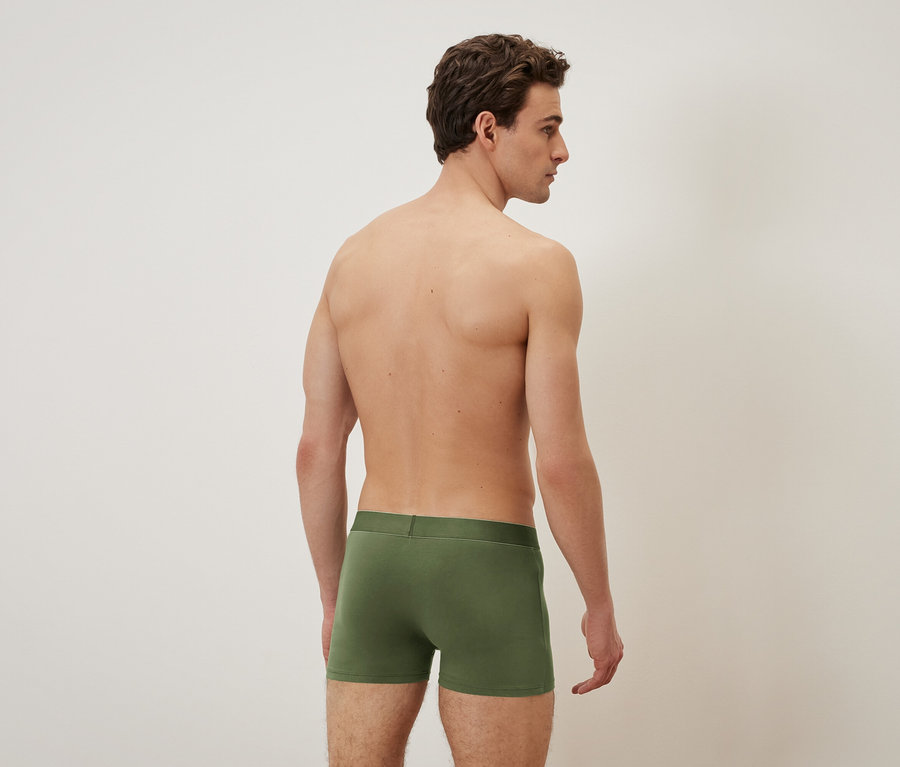 Homme de dos portant un caleçon boxeur vert.