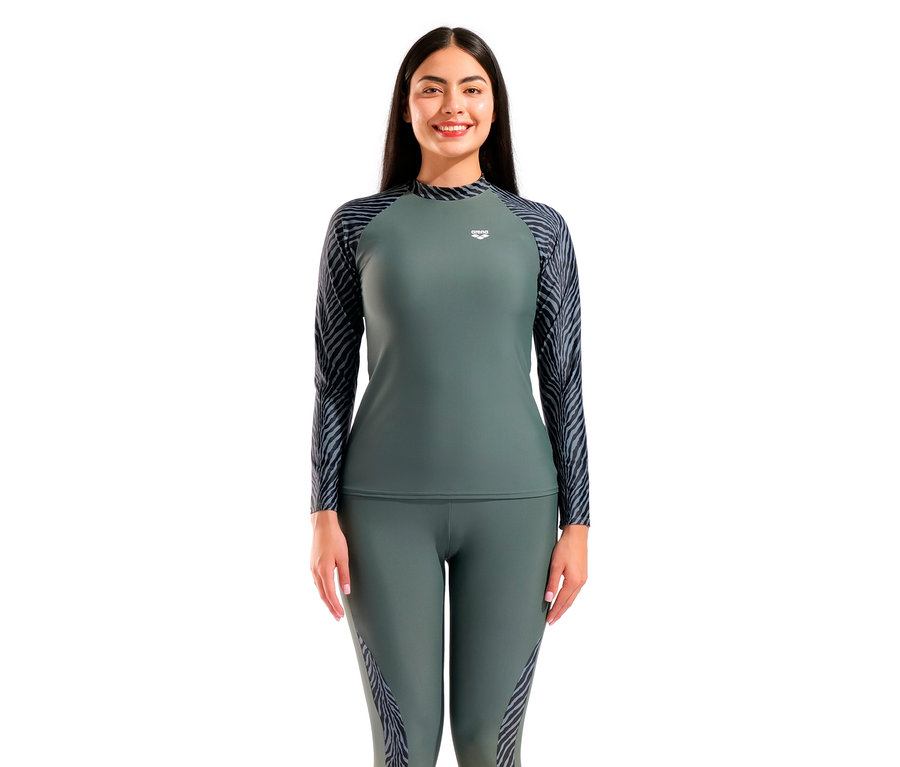 Une femme porte un haut de sport olive à manches longues et un legging avec un motif zébré sur les manches et les côtés.