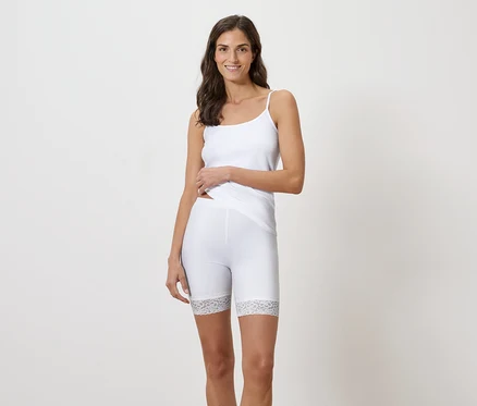 Femme portant un débardeur blanc et un short legging bordé de dentelle.