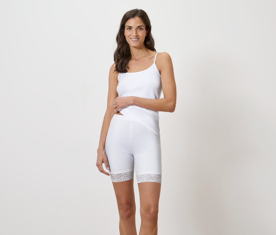 Femme portant un débardeur blanc et un short legging bordé de dentelle.
