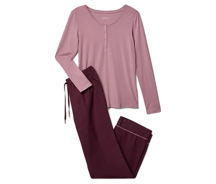 Un haut rose à manches longues boutonné est posé à côté d'un pantalon bordeaux à cordon de serrage.