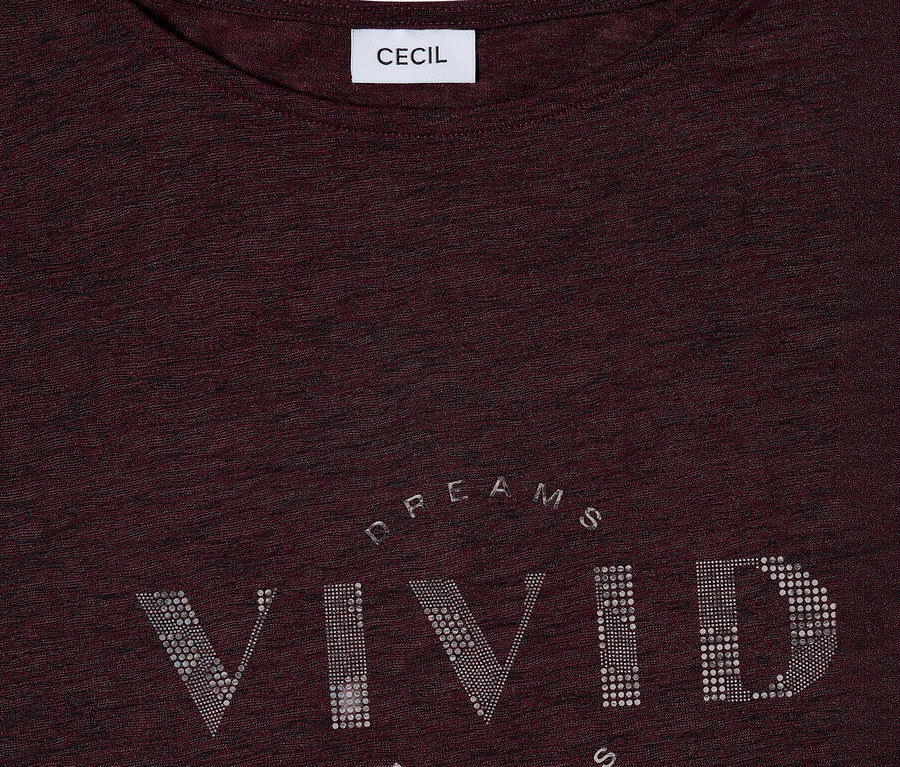 Gros plan sur un t-shirt bordeaux CECIL avec l'inscription « VIVID DREAMS » en strass argentés.