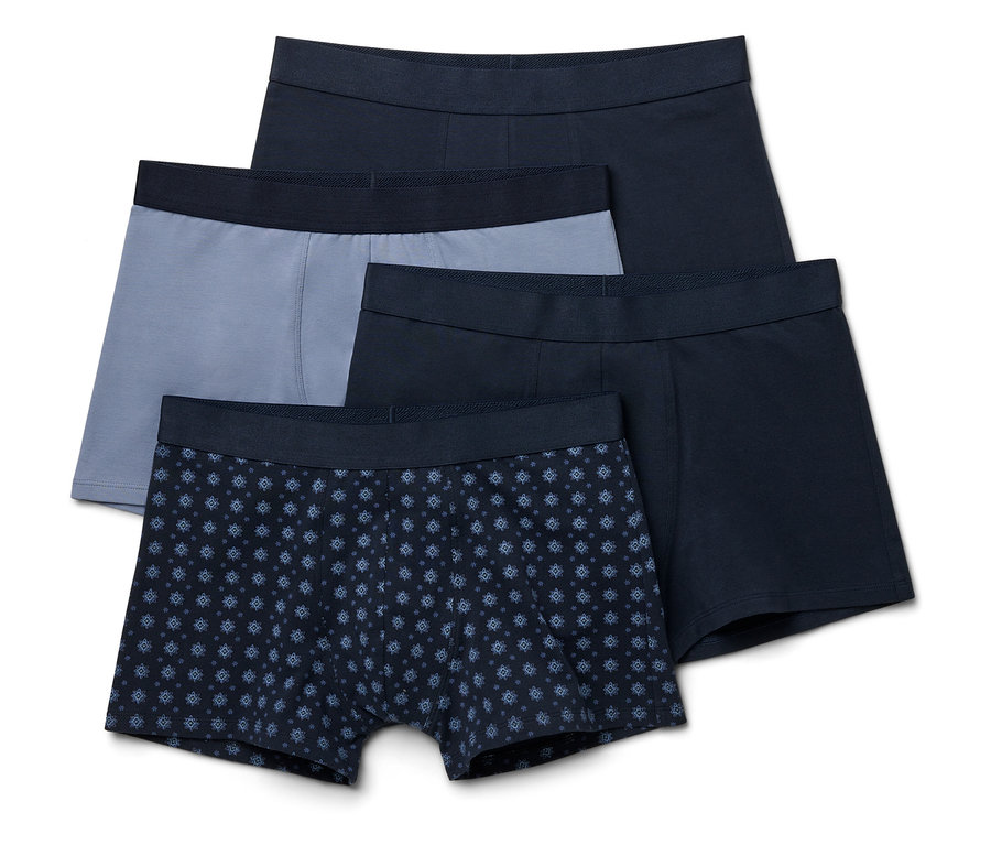 Quatre boxers bleu marine, gris et à motifs sont superposés.