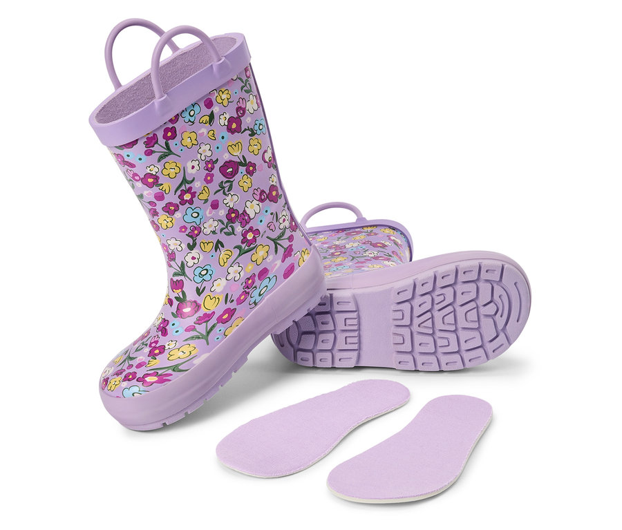 Des bottes de pluie lilas à motifs floraux et des semelles intérieures sont posées sur un fond blanc.