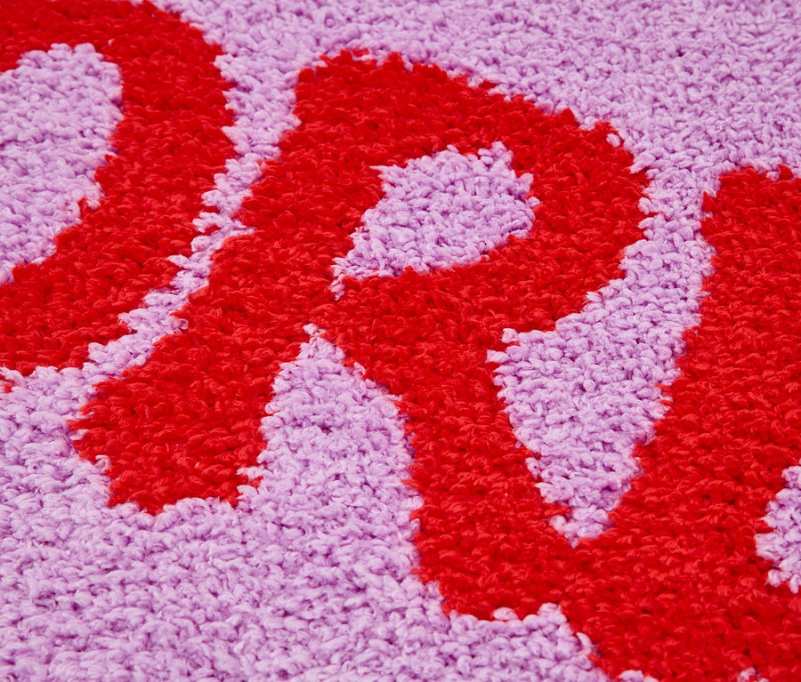 Gros plan d'un tapis violet avec une lettre rouge.