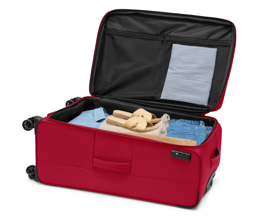 Valise à roulettes rouge ouverte, remplie de vêtements et de sandales.