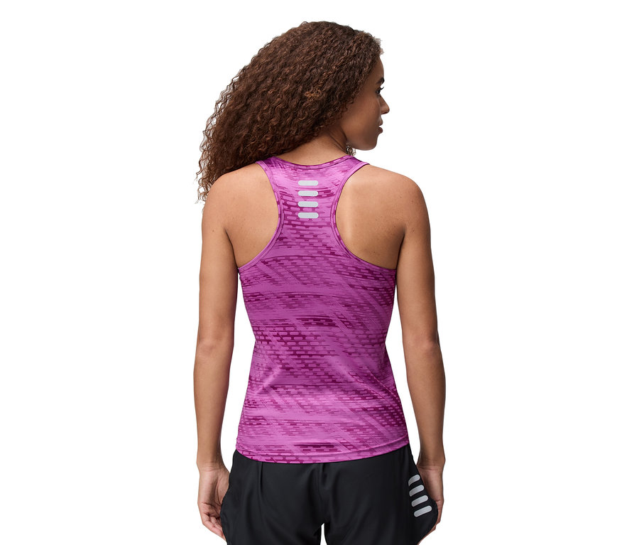 Vue arrière d'une femme aux cheveux bouclés portant un haut de sport rose sans manches et un short noir.