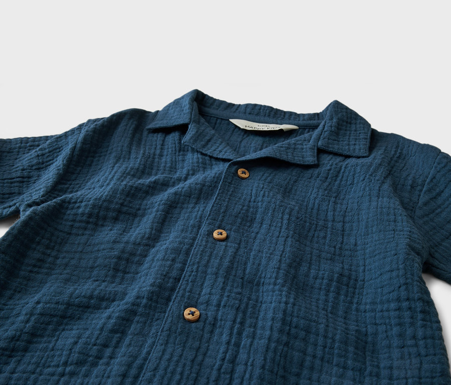 Gros plan d'une chemise bleu marine avec col et boutons.