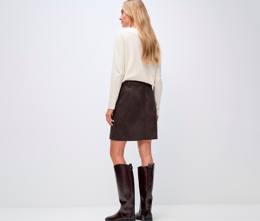 Femme vue de dos, portant un pull crème et une jupe de velours marron Street One, ainsi que des bottes marron.