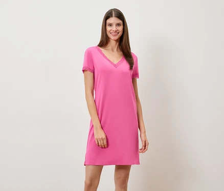 Femme portant une chemise de nuit rose à col en V et garniture en dentelle.