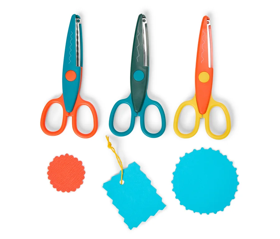 Trois paires de ciseaux zigzag orange, verte et jaune sont posées à côté d'un cercle orange, d'une étiquette turquoise et d'un cercle turquoise.