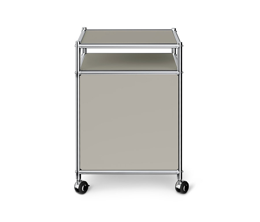 Meuble à roulettes gris clair avec cadre chromé, deux étagères et un compartiment fermé.