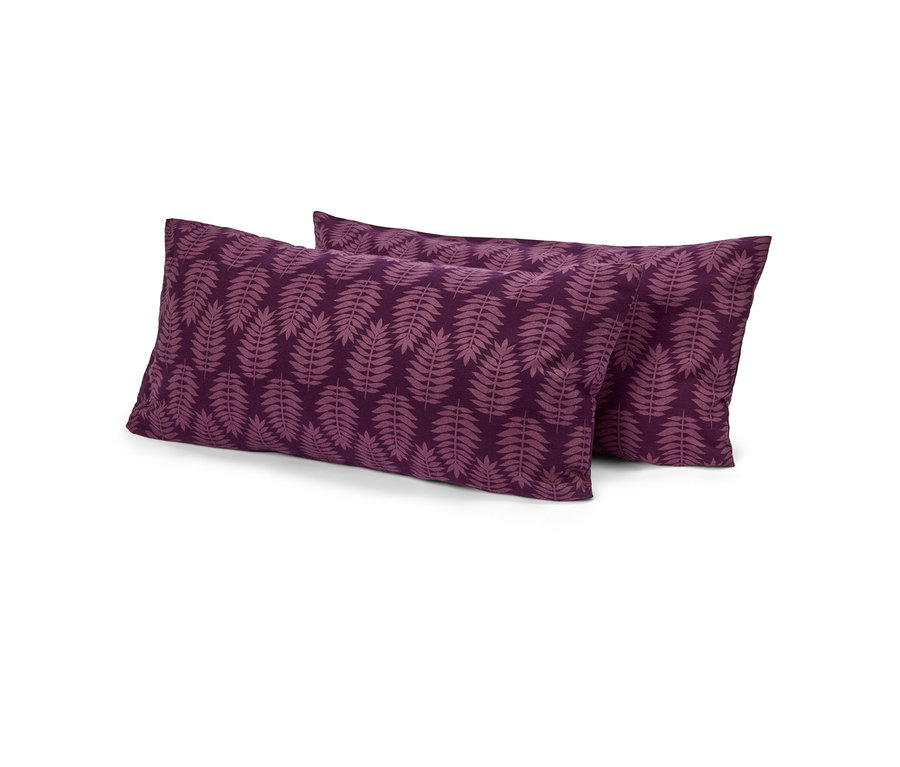 Deux oreillers rectangulaires violets avec un motif de feuilles violet clair, l'un légèrement derrière l'autre, sur fond blanc.