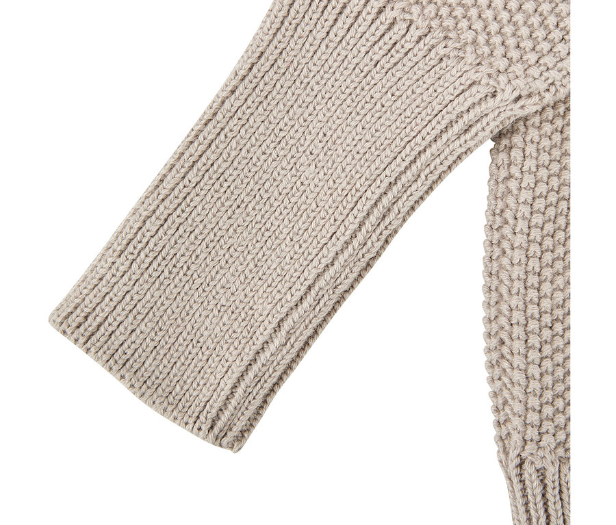 Gros plan d'un gilet bébé tricoté Sterntaler beige avec une texture. La manche présente un motif côtelé, tandis que le corps a un motif tricoté structuré différent.