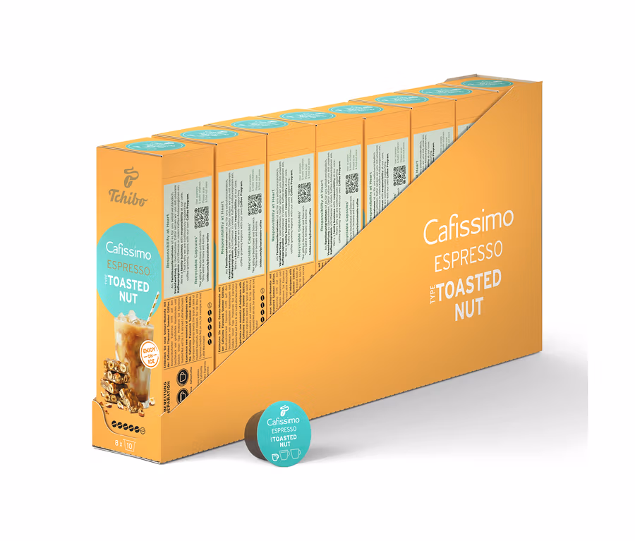 Une rangée d'emballages de capsules Cafissimo Flavoured Espresso - Tostaed Nut dans un support jaune, plus une capsule individuelle.