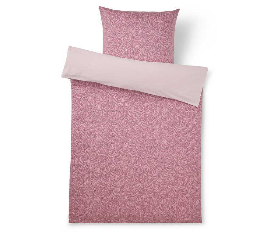 Parure de lit rose avec une housse de couette et une taie d'oreiller à motifs, présentant un motif de feuilles rose foncé sur une face et un revers rose clair uni.