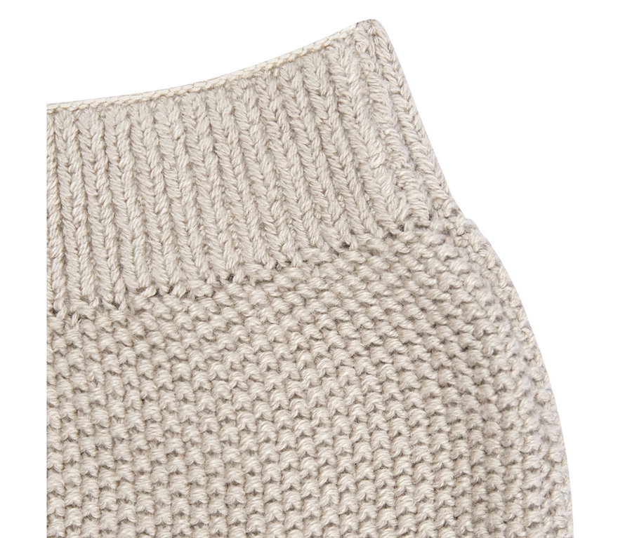 Gros plan d'un pantalon tricoté bébé Sterntaler beige clair, montrant une taille côtelée et un motif tricoté texturé.
