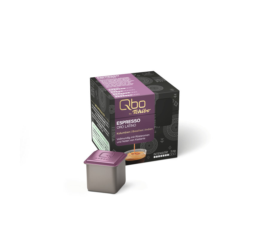 Une capsule de café Qbo Espresso ORO TOLIMA, gris foncé avec un couvercle violet, devant sa boîte gris foncé avec bande violette, inscription "Espresso Oro Latino", tasse de café et intensité 7/10.