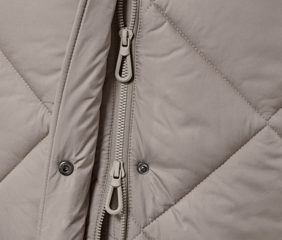 Détail d'un long gilet matelassé avec capuche.