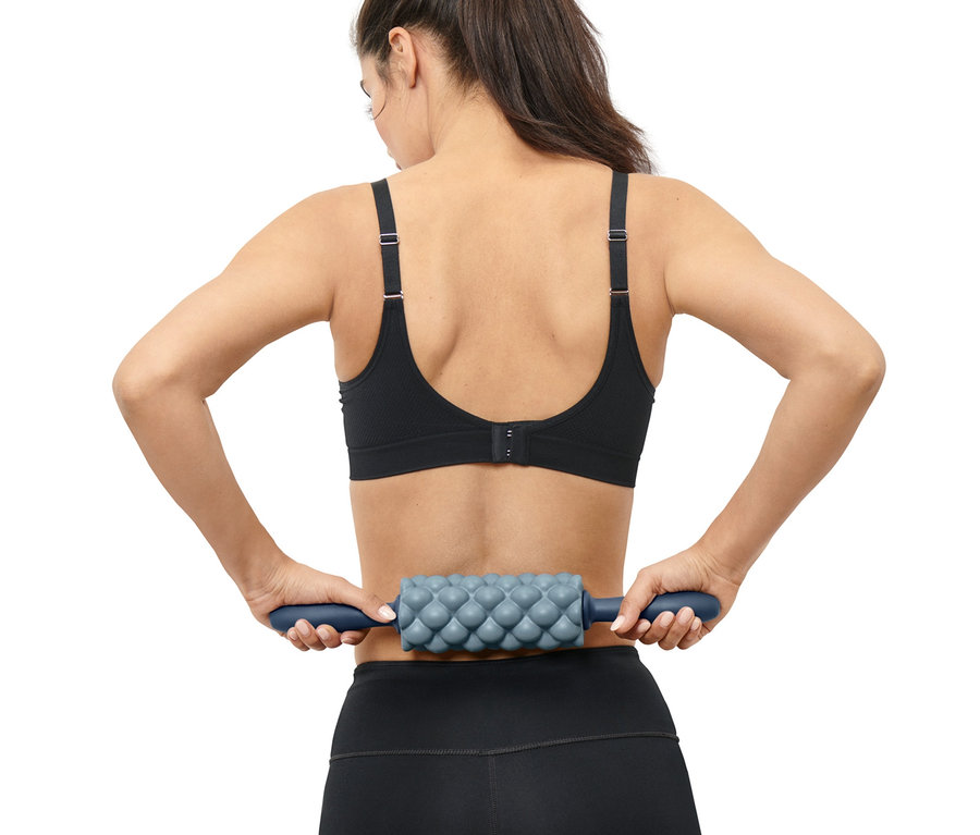 Femme utilisant un rouleau pour fascias sur son dos.