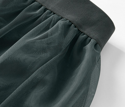 Vue détaillée d'une jupe en tulle verte avec une taille foncée.