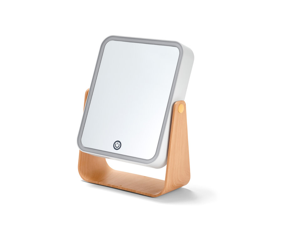 Gros plan d'un miroir cosmétique à LED sur un support en bois.