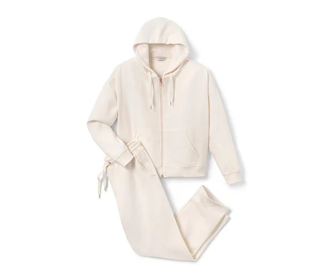 Un survêtement d’intérieur couleur crème avec une veste à capuche et un pantalon.