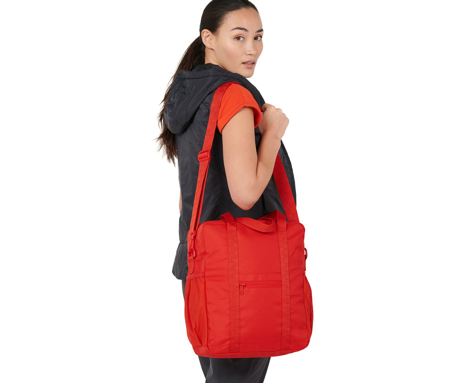 Femme portant un sac à bandoulière rouge pour vélo.