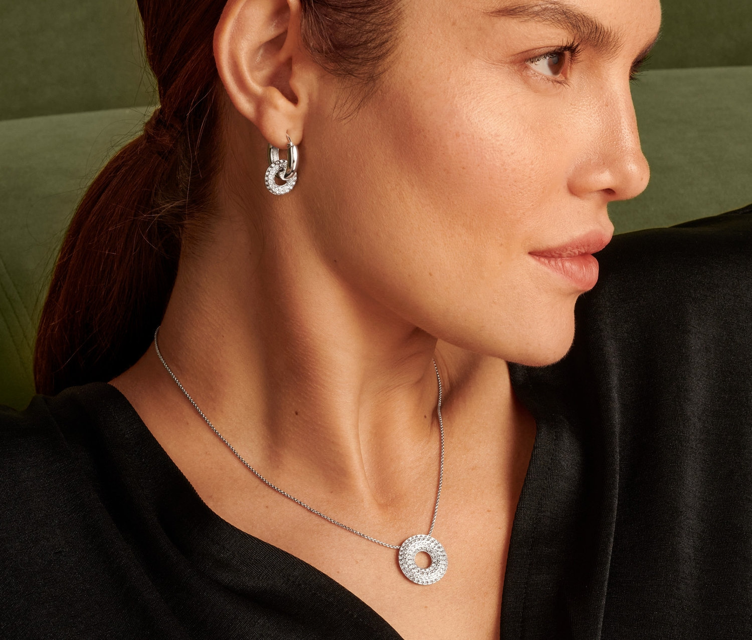 Portrait d'une femme portant un chaîne sparkle donut et des boucles d'oreilles.