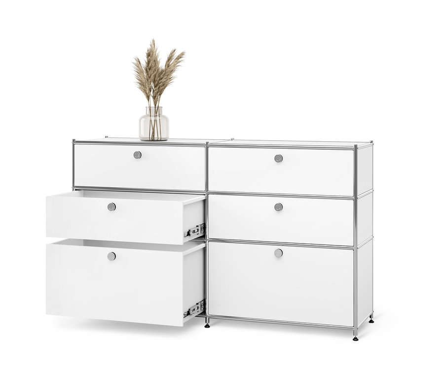 Commode en métal blanche « CN3 » avec 6 tiroirs dont deux sont ouverts. Un vase avec de l'herbe de pampa est posé sur le dessus.