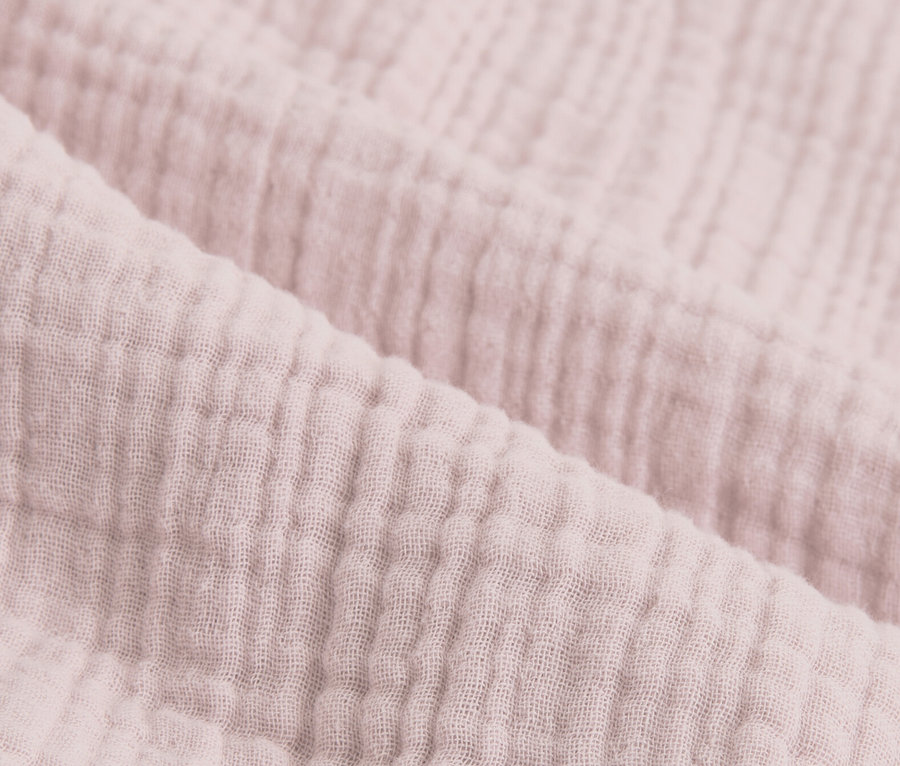Gros plan sur de la parure de lit en mousseline rose.
