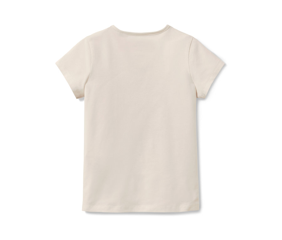 Un t-shirt couleur crème pour enfant avec des manches courtes et un motif à paillettes réversibles posé sur un fond blanc.