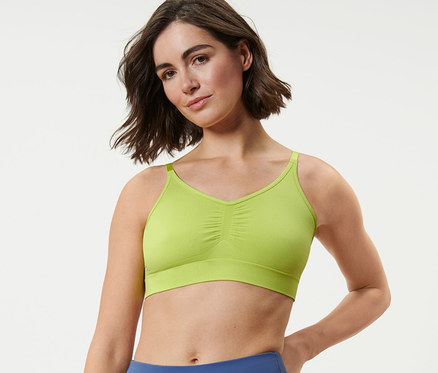 Femme portant une brassière de sport sans coutures et un legging bleu.