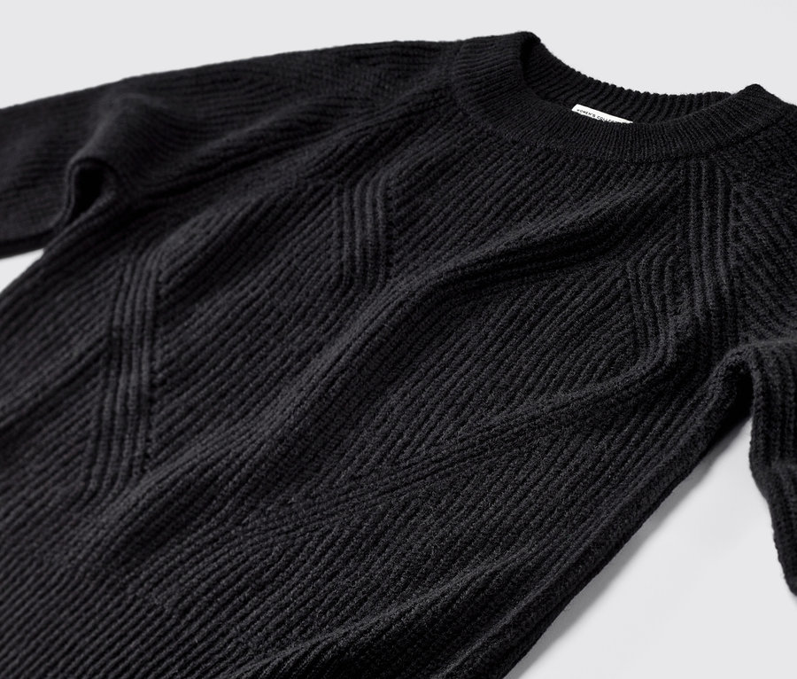 Gros plan d'un pull en maille noir.