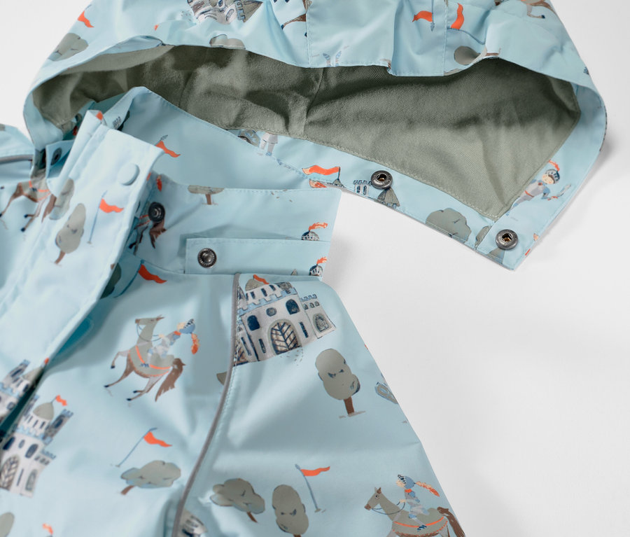 Gros plan sur une veste de pluie pour enfant à motif de chevalier.