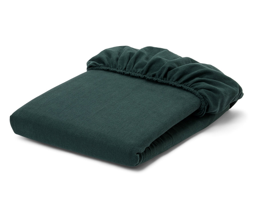 Drap-housse vert plié sur fond blanc.