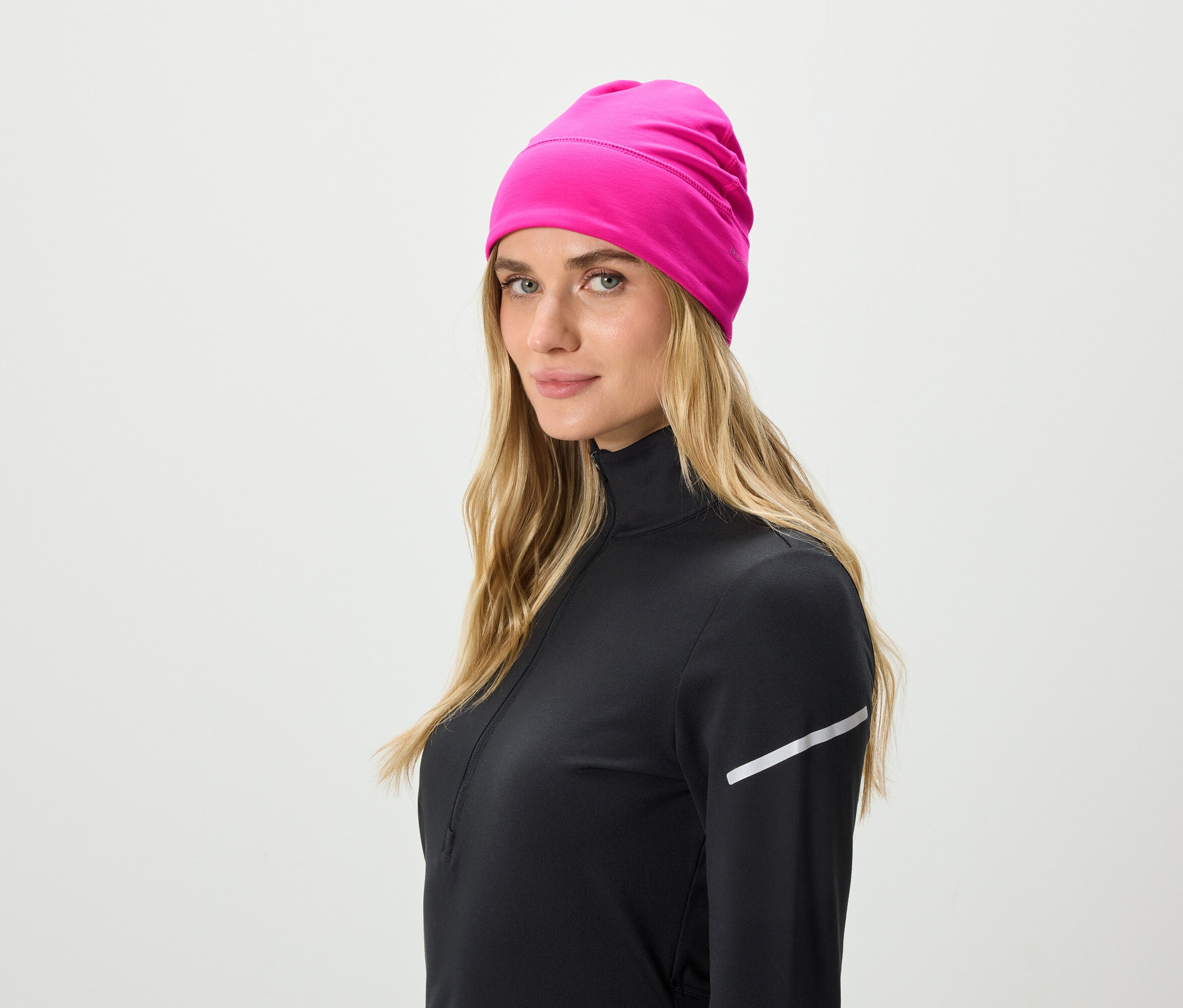 Blonde portant un haut de sport noir et un bonnet rose.