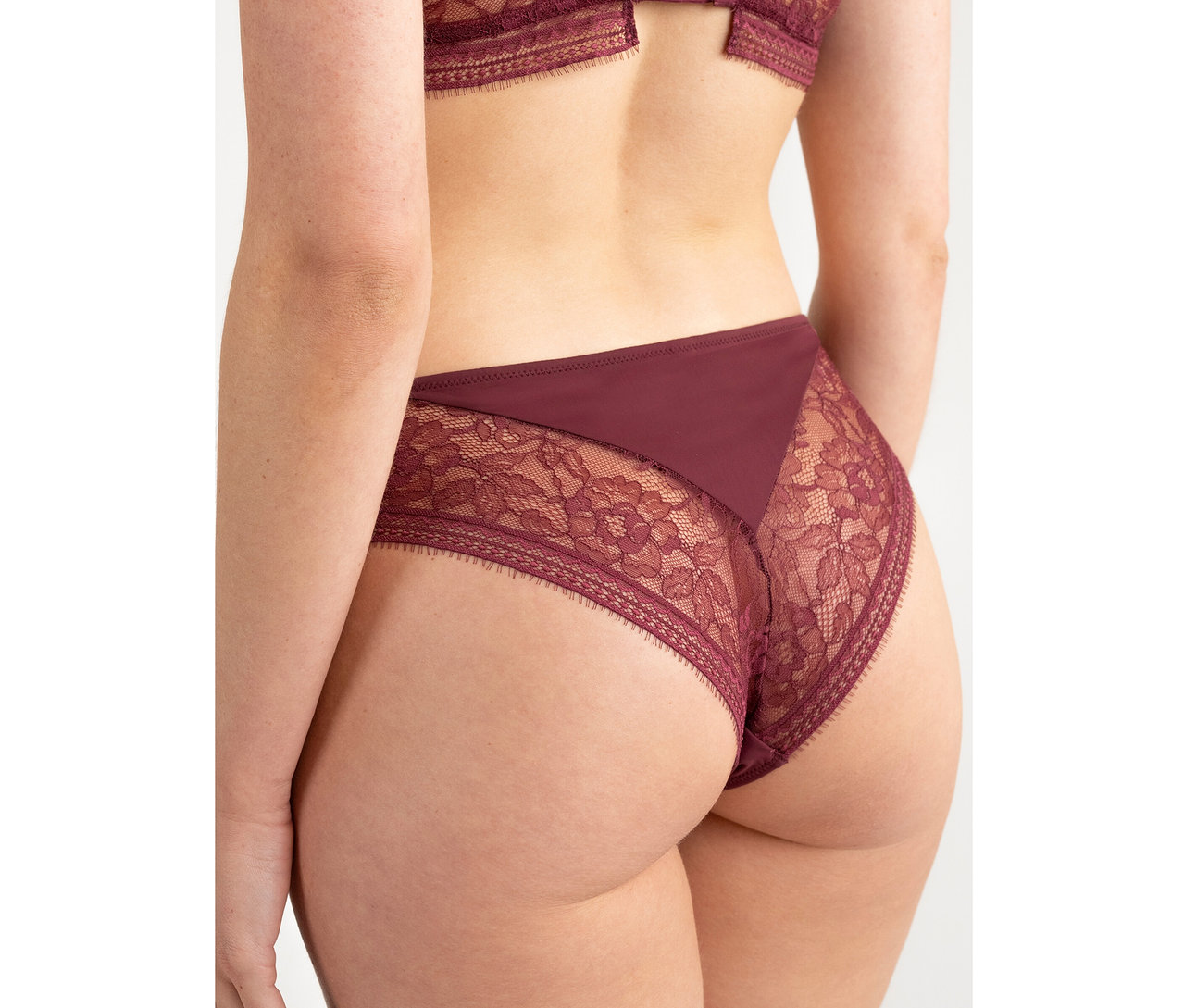 Vue de dos d'une personne portant un slip taille haute Passionata « Jeanne » bordeaux avec des détails en dentelle.