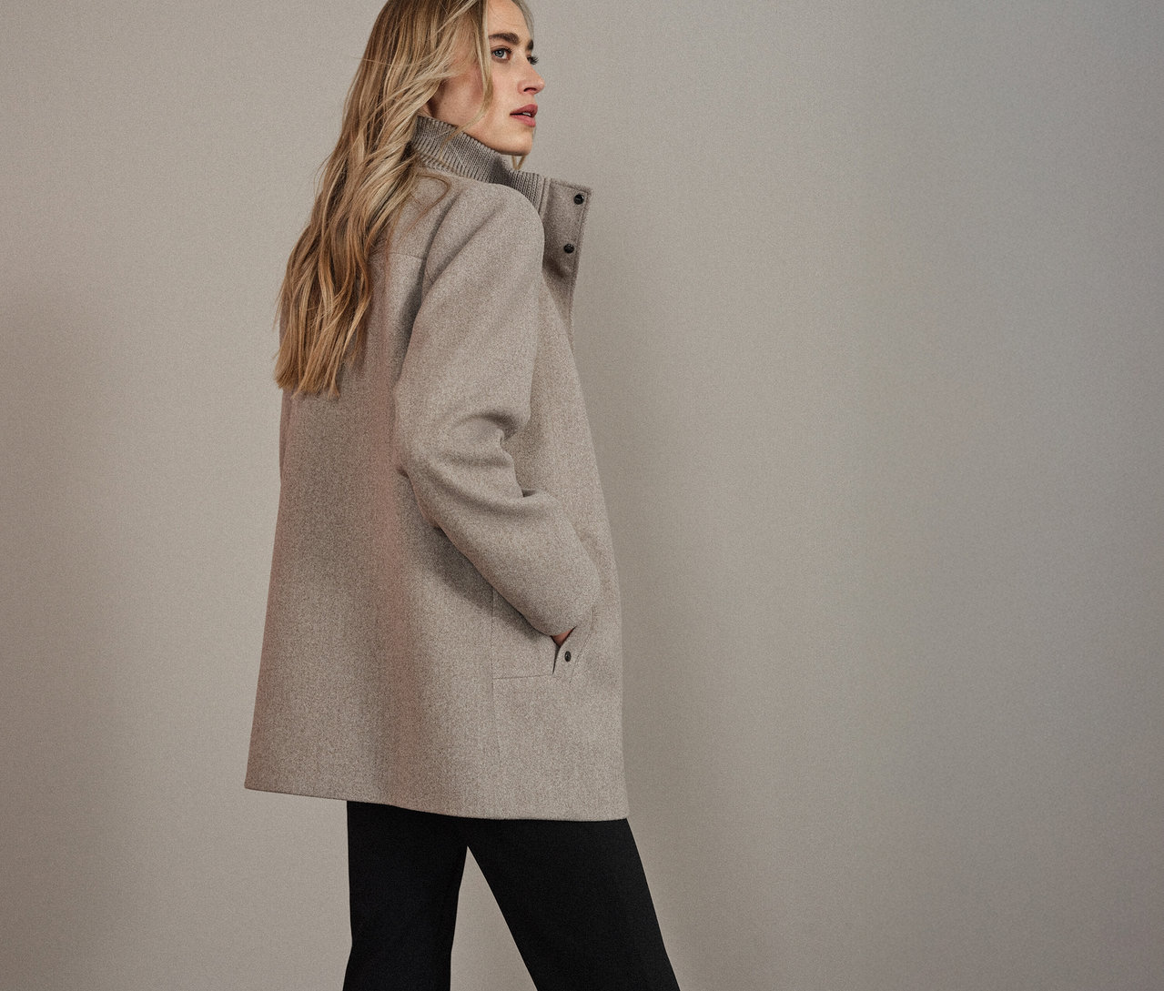 Femme portant un manteau court Street One, regardant vers la gauche.