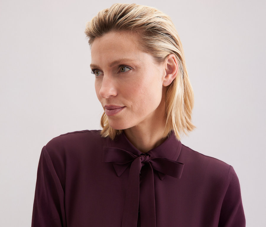 Femme portant une blouse à col lavallière en viscose Seidensticker.