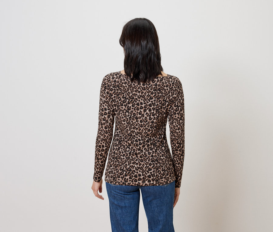 Une femme, vue de dos, porte un haut marron à manches longues avec un motif animalier et un jean bleu.